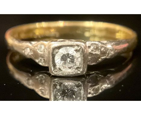 An 18ct gold diamond ring, the central stone mounted in platinum, each shoulder set with three diamond chips, size M/N, 2.2g 