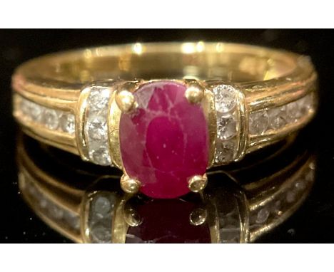 An 18ct gold ring, set with a central faceted ruby, the shoulders channel set with six vertical and eight horizontal diamonds