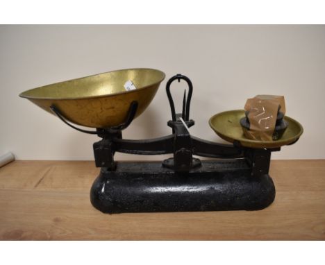 A set of vintage cast metal and brass scales with weights.