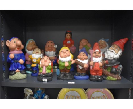 An assorted collection of vintage garden gnomes, including Snow White and the Seven Dwarves