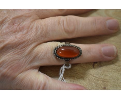 A ladies Carnelian style ring with white metal band
