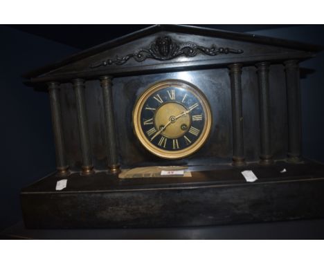 A Victorian black slate mantel clock, of Architectural form, with enamelled Roman dial, two train movement, and measuring 30c