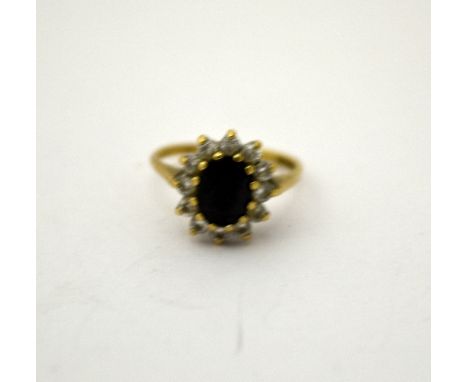 A 9CT GOLD SAPPHIRE CLUSTER RING, with central sapphire within a surround of paste stones, ring size K