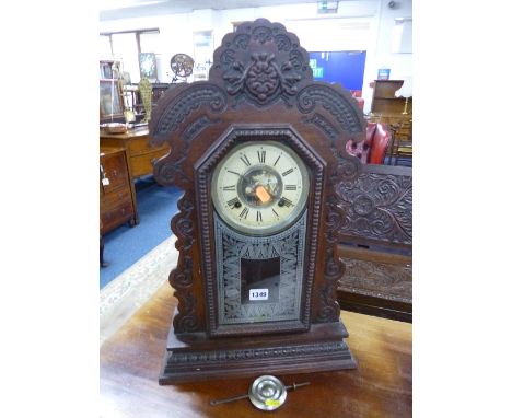 AN OAK CASED AMERICAN GINGERBREAD CLOCK, face marked 'The Ansonia Clock Co) (pendulum)