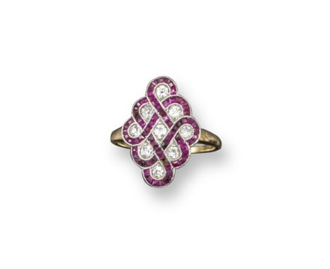 An Edwardian ruby and diamond set lattice form ring, the scrolls of calibre-cut rubies are set around the nine circular-cut d