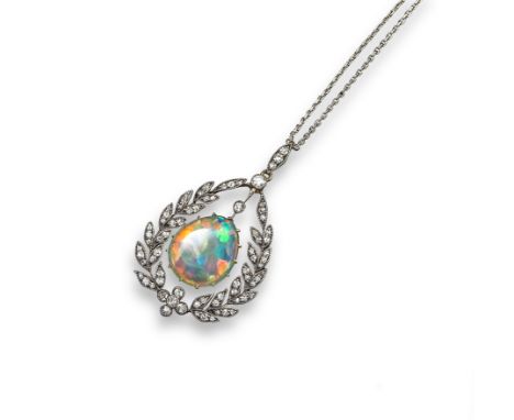 An Edwardian opal and diamond pendant, the fine pear-shaped opal suspends from a laurel form surround, millegrain-set with sm