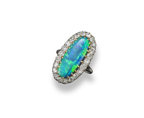 A boulder opal and diamond ring, the elongated oval cabochon boulder opal is set within a surround of circular-cut diamonds i