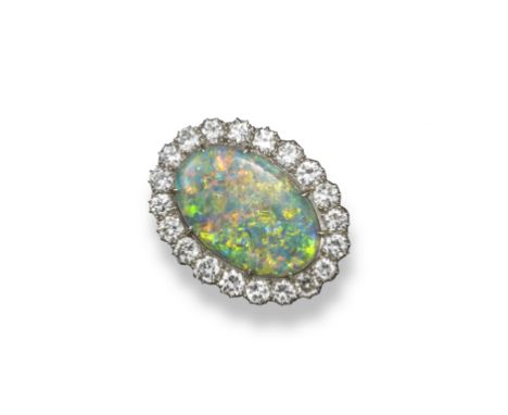 An opal and diamond cluster brooch, the oval-shaped opal is set within a surround of twenty circular-cut diamonds in platinum