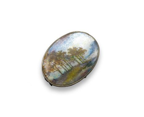 An Arts and Crafts silver and enamel brooch, of oval form and depicting a realistic wooded scene in polychrome enamel. In the