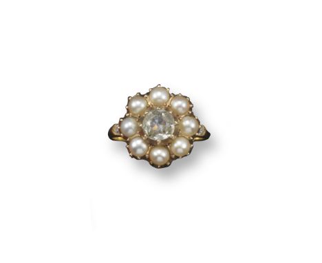 A pearl and diamond cluster ring, set with an old cushion-shaped diamond within a border of seed pearls in yellow gold. Size 