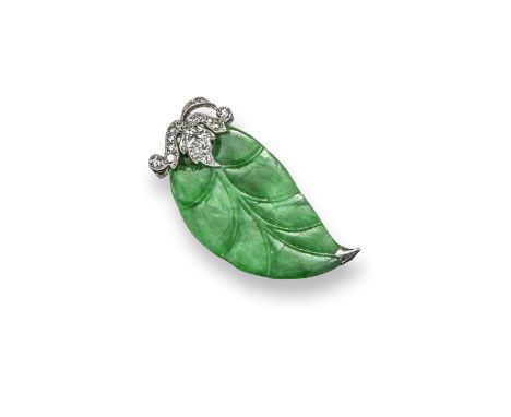 A jade and diamond brooch, the carved jade leaf is set with graduated circular-cut diamonds to the platinum stem. With indist
