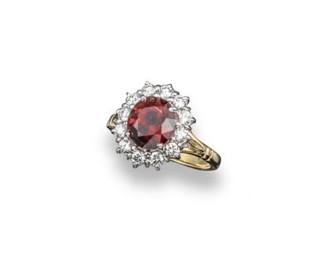 A spinel and diamond cluster ring, the oval-shaped spinel weighs approximately 4.00cts and is set within a surround of twelve