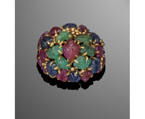 A gold bombe ring mounted with foliate carved emeralds rubies and sapphires, the Tutti Frutti ring with heavily fluted shank.