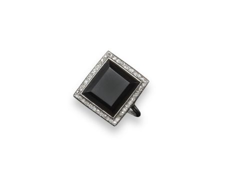 An Art Deco black onyx and diamond plaque ring, the rectangular bevel-edged section of black onyx is set within a surround of