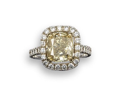 A cushion-shaped fancy coloured diamond ring, the diamond weighs approximately 4.21cts and is set within a surround of round 