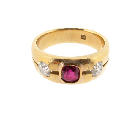 A ruby and diamond three stone ring, the emerald-cut ruby is set either side with an old cushion-shaped diamond in yellow gol