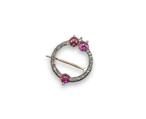 A diamond and ruby circular brooch by Giuliano, set with small cushion-shaped diamonds and three cabochon rubies in silver an