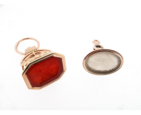 Two hardstone mounted gold fob seals. One depicting an elaborate hunting scene, the other with a coat of arms.