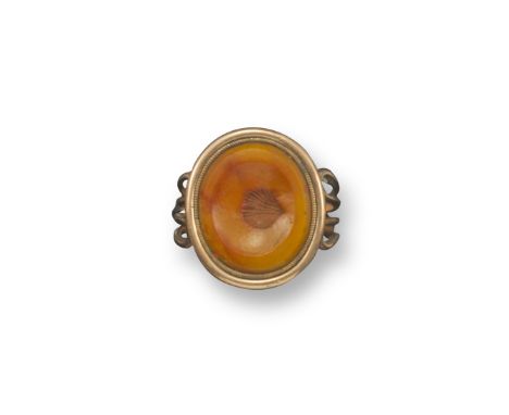 A George III agate and gold ring, the oval agate section incorporates the impression of a small scallop shaped shell. Four wi