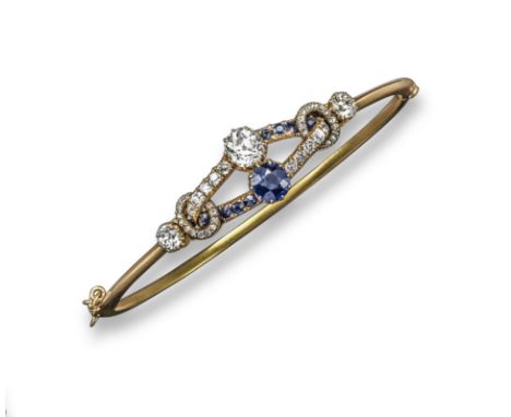 A sapphire and diamond set hinged bangle, set with a larger cushion-shaped diamond and larger oval-shaped sapphire and furthe