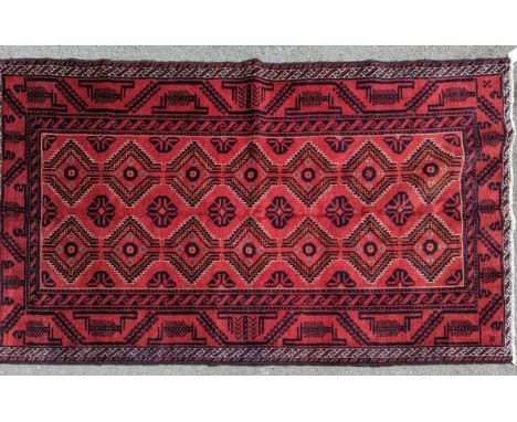 A 20th century north east Persian turkoman floor rug carpet. Having a red ground with geometric repeating motifs to the centr