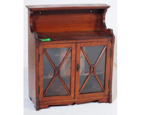 A Victorian 19th century mahogany hanging bookcase wall cabinet. Raised on shaped serpentine carved base with twin astragal g