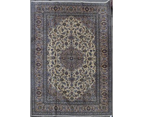 A 20th century central Persian Kashan carpet floor rug. Having a cream ground with a large floral central medallion, surround