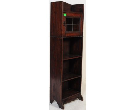 A 1920's oak pedestal bookcase cabinet. Upright pedestal form with open window bookcase having single glass panel door atop. 