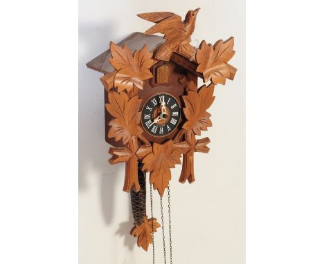 A contemporary Black Forest German Bavarian wall hanging cuckoo clock. Having a carved detailed exterior, white chapter ring 