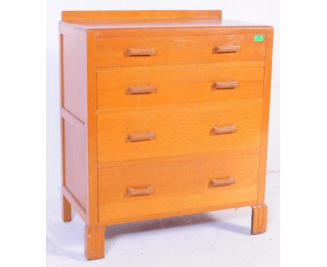 A 1930's Art Deco golden oak chest of drawers. The chest being raised on bracket feet with an upright body of four drawers ha