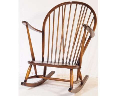 Ercol Furniture - A vintage 20th century dark elm stick back Windsor rocking chair. Arched back rest into curved elbow rests 