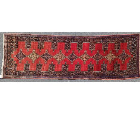 A 20th century north west Persian senneh runner floor rug carpet. Having a red ground with repeating central medallion patter