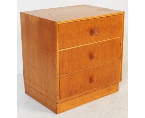 A mid century retro Meredew light oak bedside chest of drawers. Raised on an inset plinth base with upright body comprising s