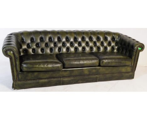 A late 20th century button backed three seater sofa settee couch with arm chair in a chesterfield style. In a green colour wi