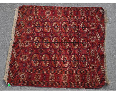 A small proportioned 20th century Persian Bokhara / Bukhara carpet floor rug. Featuring traditional three rows of central med