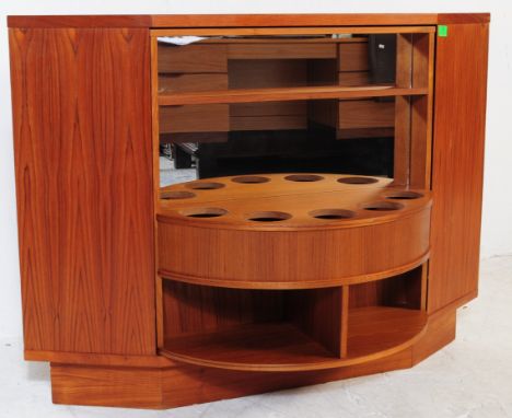 A vintage 1970's Danish teak wood veneer cocktail drinks corner cabinet.&nbsp;Having a two tambour fronted shelf section with