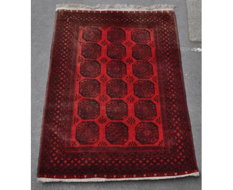 A 20th century Afghan Aqcha carpet floor rug, in the manner of Khal Mohammadi. Having a red ground, with dark patterning. Fea