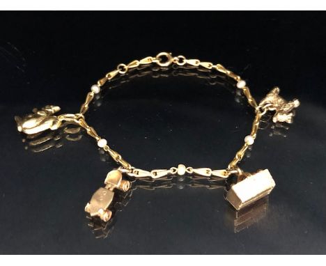 9ct Gold Charm bracelet with five interlinked seed pearls and four charms to include Scotty Dog, roller-skate, basket and a 1