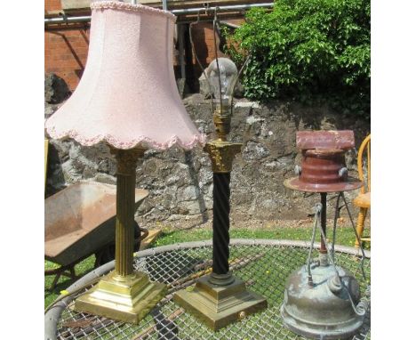 A gilt and black metal Corinthian column table lamp, together with another similar table lamp and another lamp