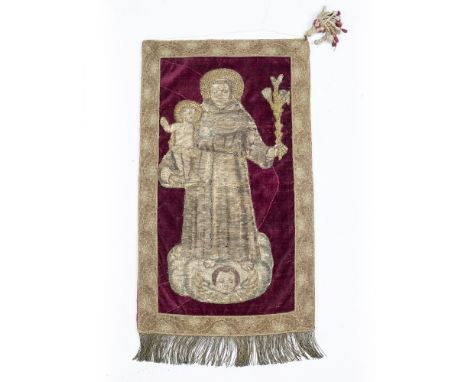 AN ANTIQUE CONTINENTAL NEEDLEWORK PANEL depicting St Frances holding the Holy Child, later mounted on velvet and within a flo