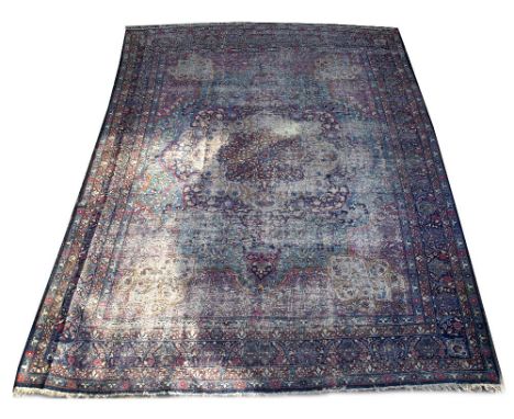 A MIDDLE EASTERN BLUE GROUND SMALL CARPET with a large central flowerhead motif, a banded border and styalised foliate decora