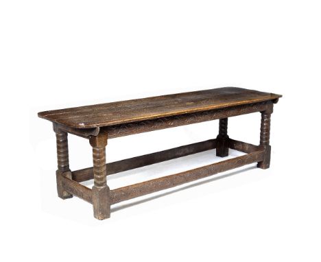 A 17TH CENTURY STYLE OAK REFECTORY TABLE with two planked top, bobbin turned legs united by carved stretchers, decorated with