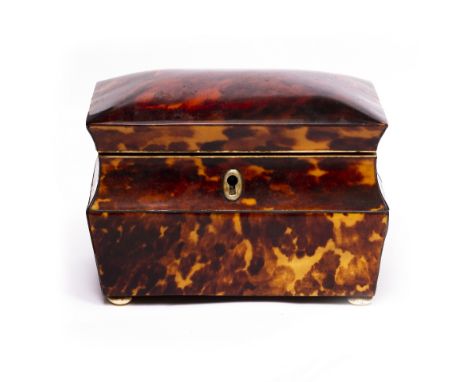 A 19TH CENTURY TORTOISE SHELL TEA CADDY of sarcophagus form with two lidded compartments within and standing on ivory bun fee