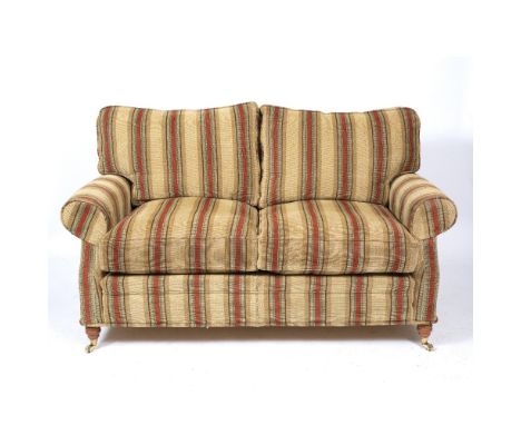 A CONTEMPORARY TWO SEATER SOFA with scrolling arms, striped upholstery, turned front legs and brass casters, 174cm wide x 104