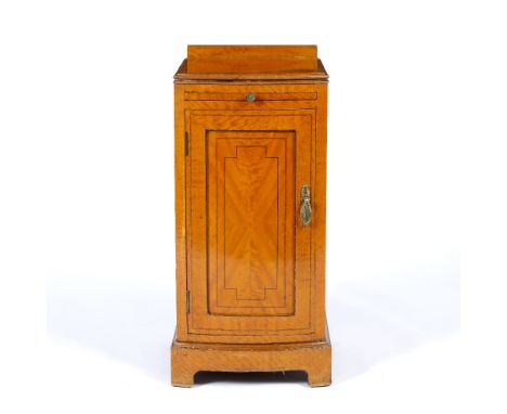 A SATINWOOD BOW FRONTED POT CUPBOARD with slide over a panel door and standing on bracket feet, 36cm wide x 39cm deep x 74.5c