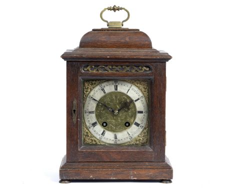 A GEORGIAN STYLE OAK CASED MANTLE CLOCK with brass carrying handle, the engraved brass dial with silvered chapter ring, the m