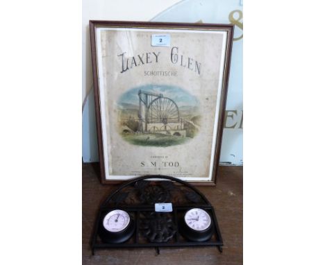 A framed print and a clock/temperature gauge