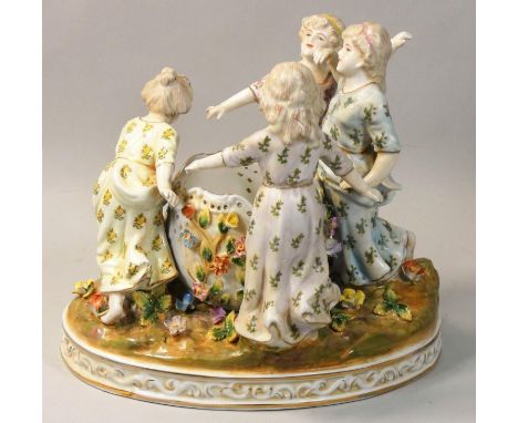 A Meissen style 20th century porcelain figure group, modelled as four girls dancing in a circle around a well, on a naturalis