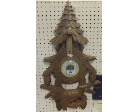 A Black Forest style barometer decorated with fir tree and pine cones and bird