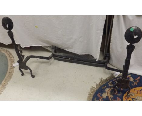 A large black painted wrought iron fire dog with spit rests, two further pairs of vintage wrought iron fire dogs, a brass fir